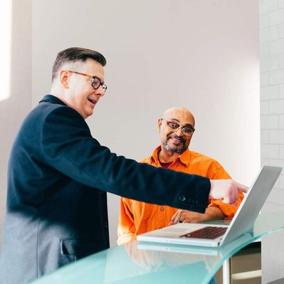 Retouching "after" edit example. Two men having a relaxed business meeting in an office lobby with the background changed to a more neutral setting using photoshop retouching.