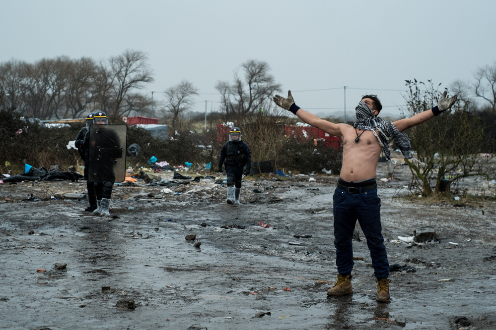 Un migrant manifestant devant des CRS - 3Ë jour de dÈmantËlement de la moitiÈ sud de la Jungle de Calais, le 02/03/2016