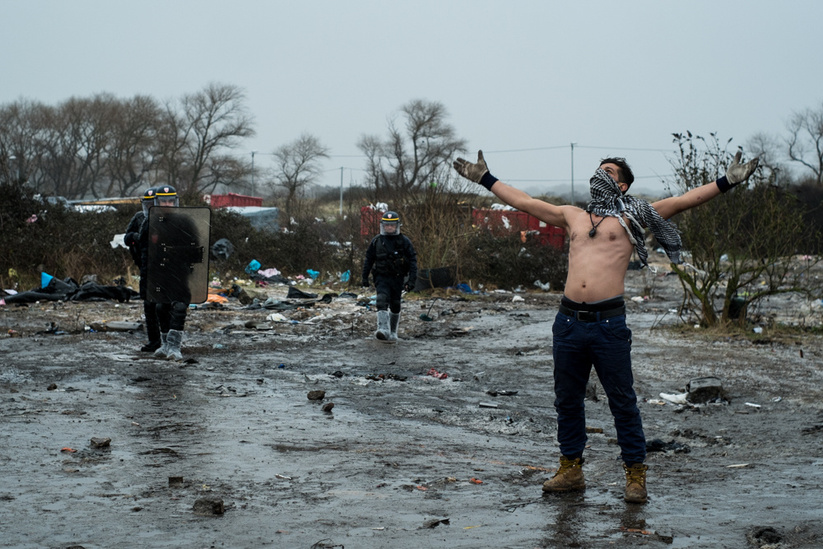 Un migrant manifestant devant des CRS - 3Ë jour de dÈmantËlement de la moitiÈ sud de la Jungle de Calais, le 02/03/2016