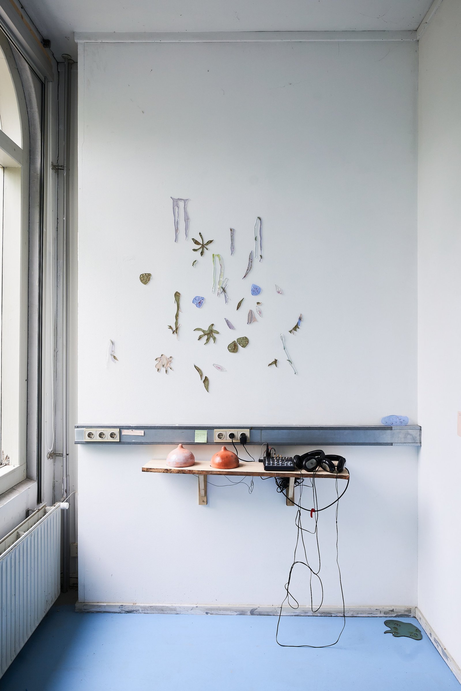 Hand cut glass works and ceramic sound installation on wooden shelf.