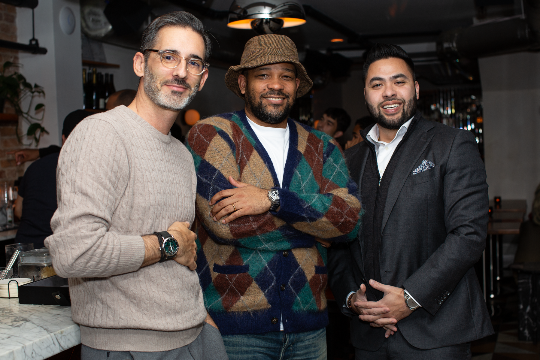 Three hip-looking men smile for the NYC photographer at an event in a downtown bar. 