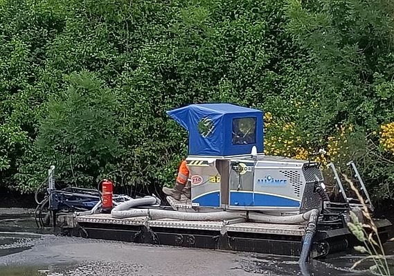 Dragage et curage de boue liquide à l'aide d'un radeau
