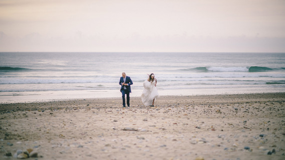 una pareja de novios paseando por la playa