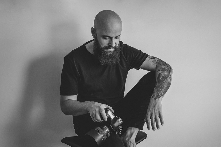 retrato de fotógrafo sentado con una cámara en la mano