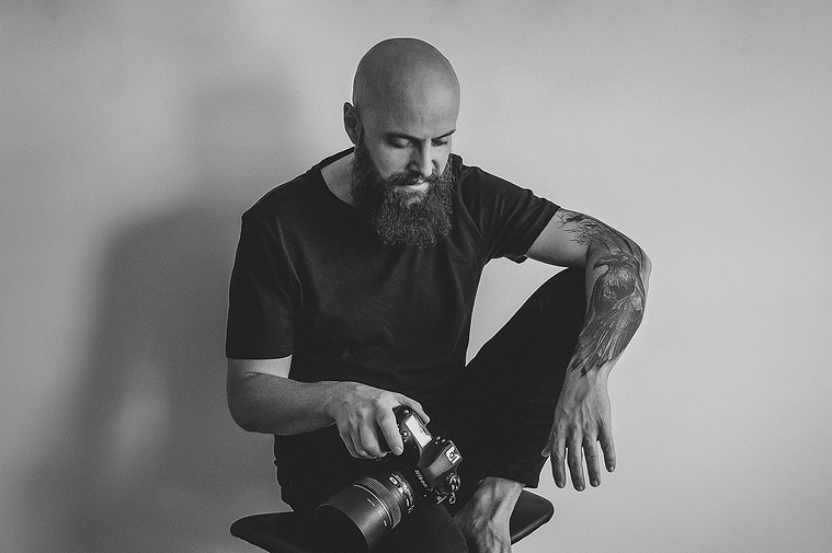 retrato de fotógrafo sentado con una cámara en la mano