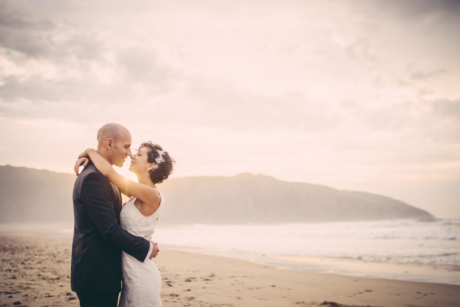 pareja de novios abrazados en la playa