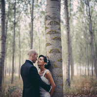 pareja de novios apoyados en un arbol
