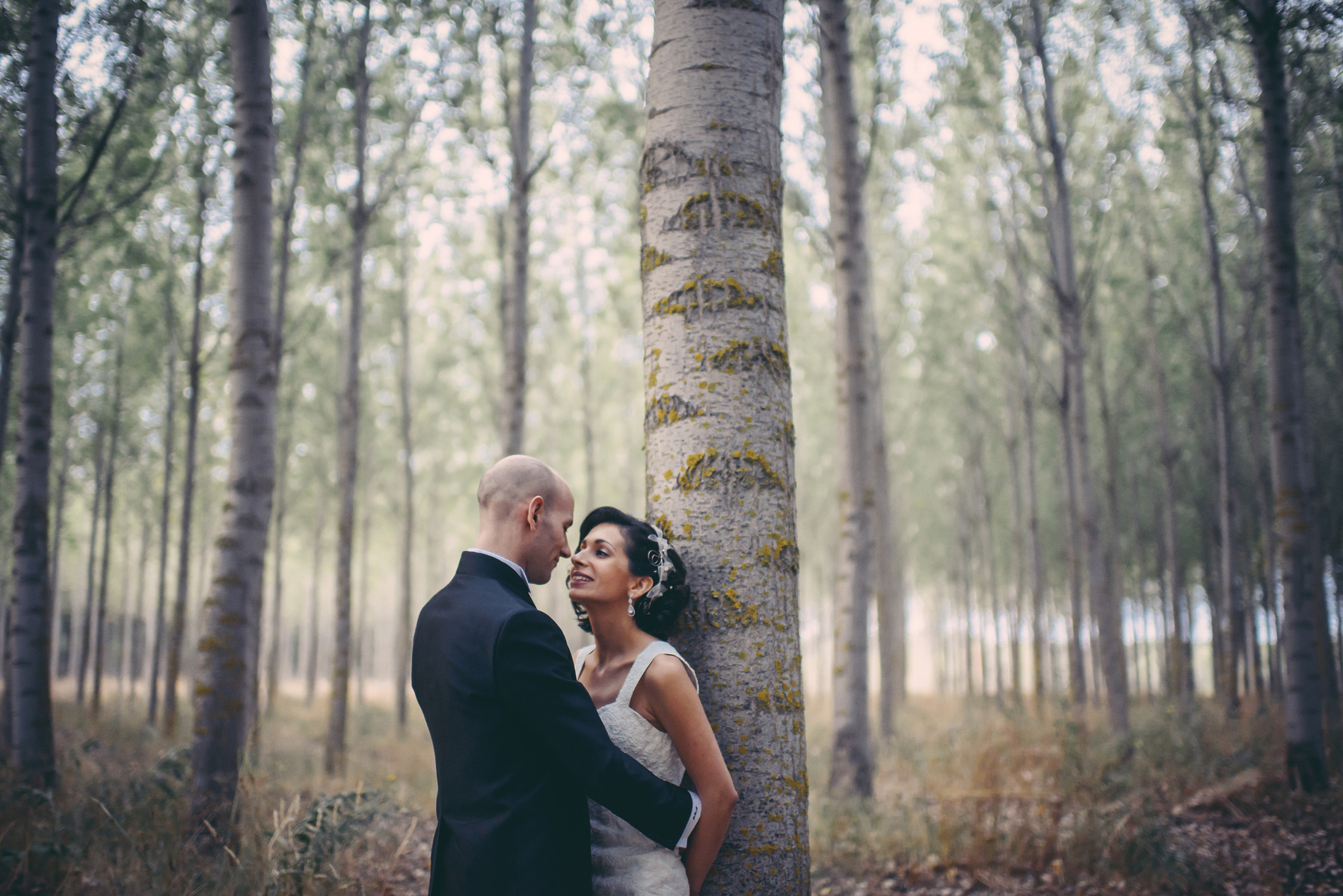 pareja de novios apoyados en un arbol