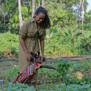 Sabrina Elba in rice paddy, with daughter of local farmer.
UN Goodwill Ambassadors for IFAD - Idris and Sabrina Elba visit Maboikandoh, Sierra Leone. 