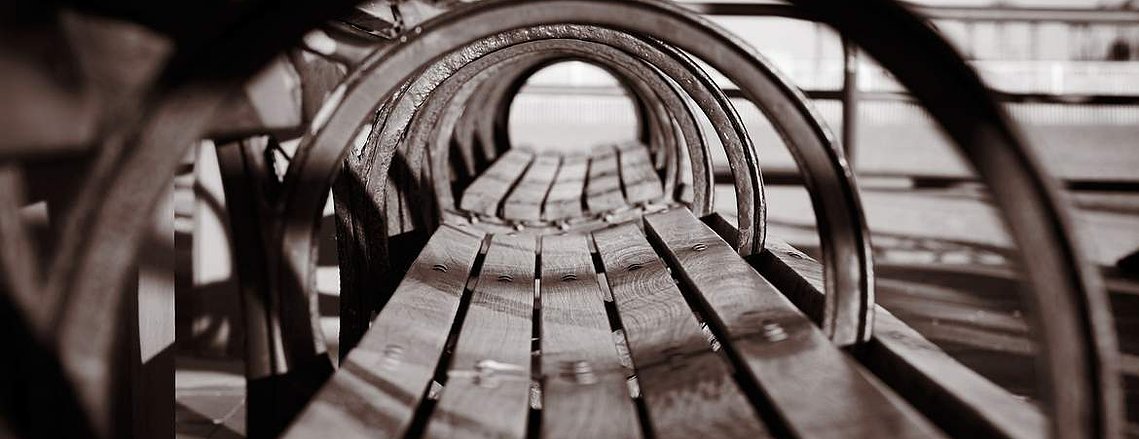 Sepia toned side angle of a park bench on Coney Island, NY.  Street photography prints for sale.  Photo by Loren Scott Fiedler.