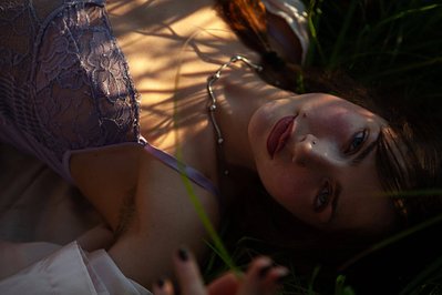 A girl having a sensual summer photoshoot during the sunset in lingerie wearing lipstick 