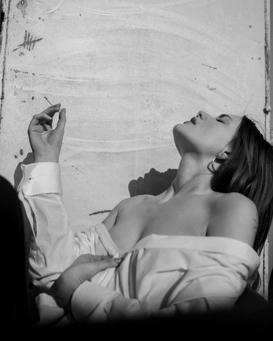 A young woman wearing a white shirt in black and white photoshoot 