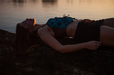 Woman wearing blue lingerie  during her sunset outdoor photoshoot 