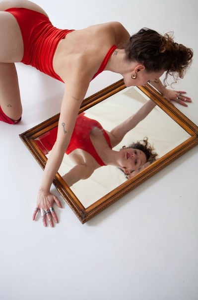 Woman looking at the mirror in a red lingerie 