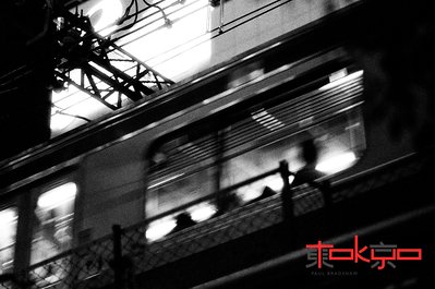A train travels through Shibuya Tokyo at night.