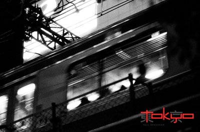 A train travels through Shibuya Tokyo at night.