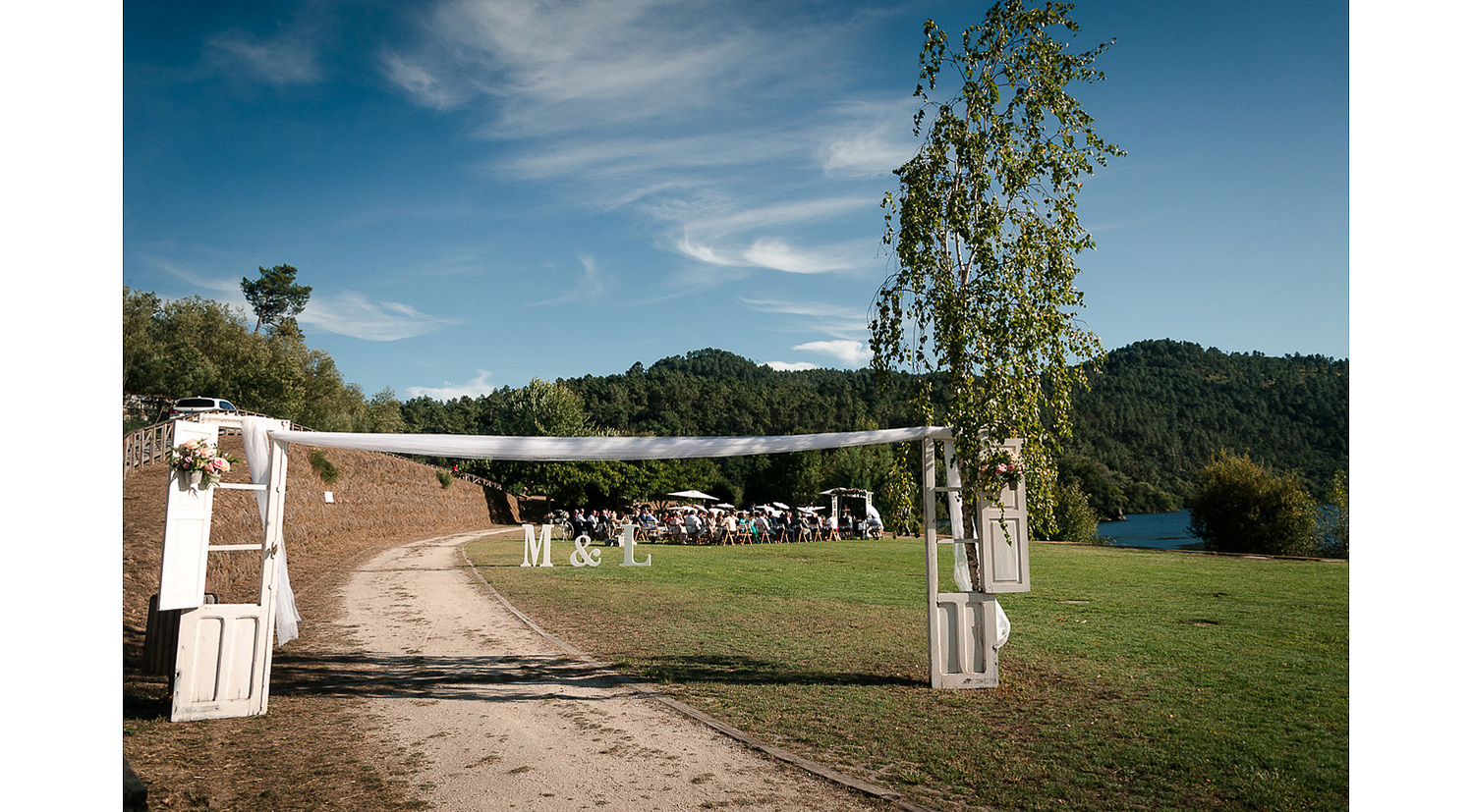 Decoracion de boda al aire libre en verano, con dos puertas blancas en jardin en el Balneario de Arnoia, Ourense