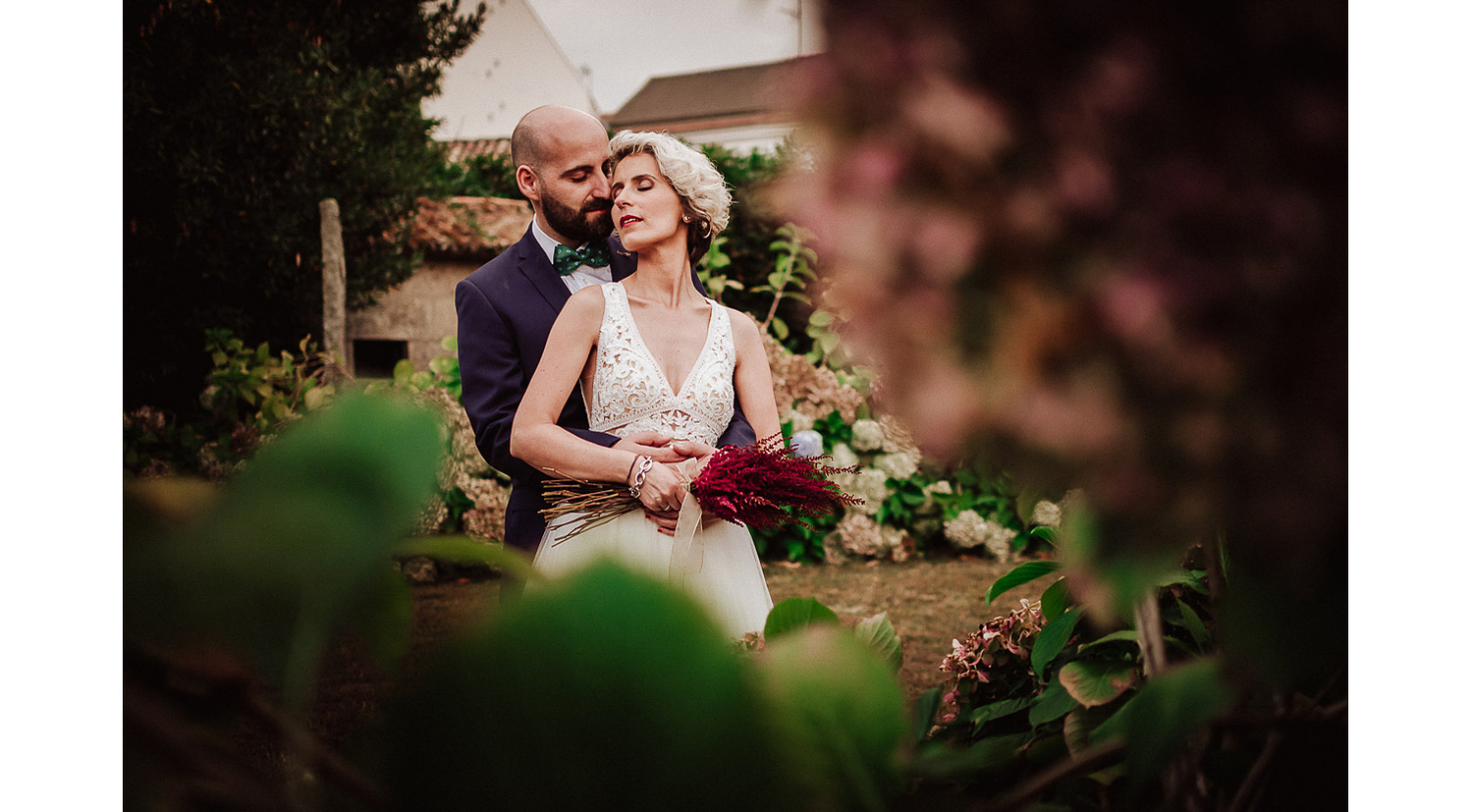 Fotografia de boda en jardin con flores y novios abrazados  cariñosamente en Castro do Balneario Galicia