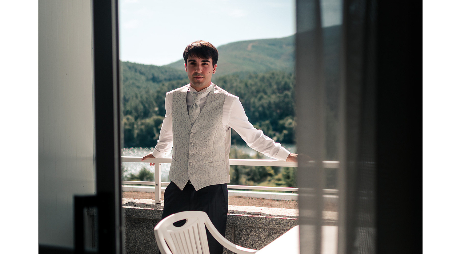Novio antes de la boda con chaleco en el balcón