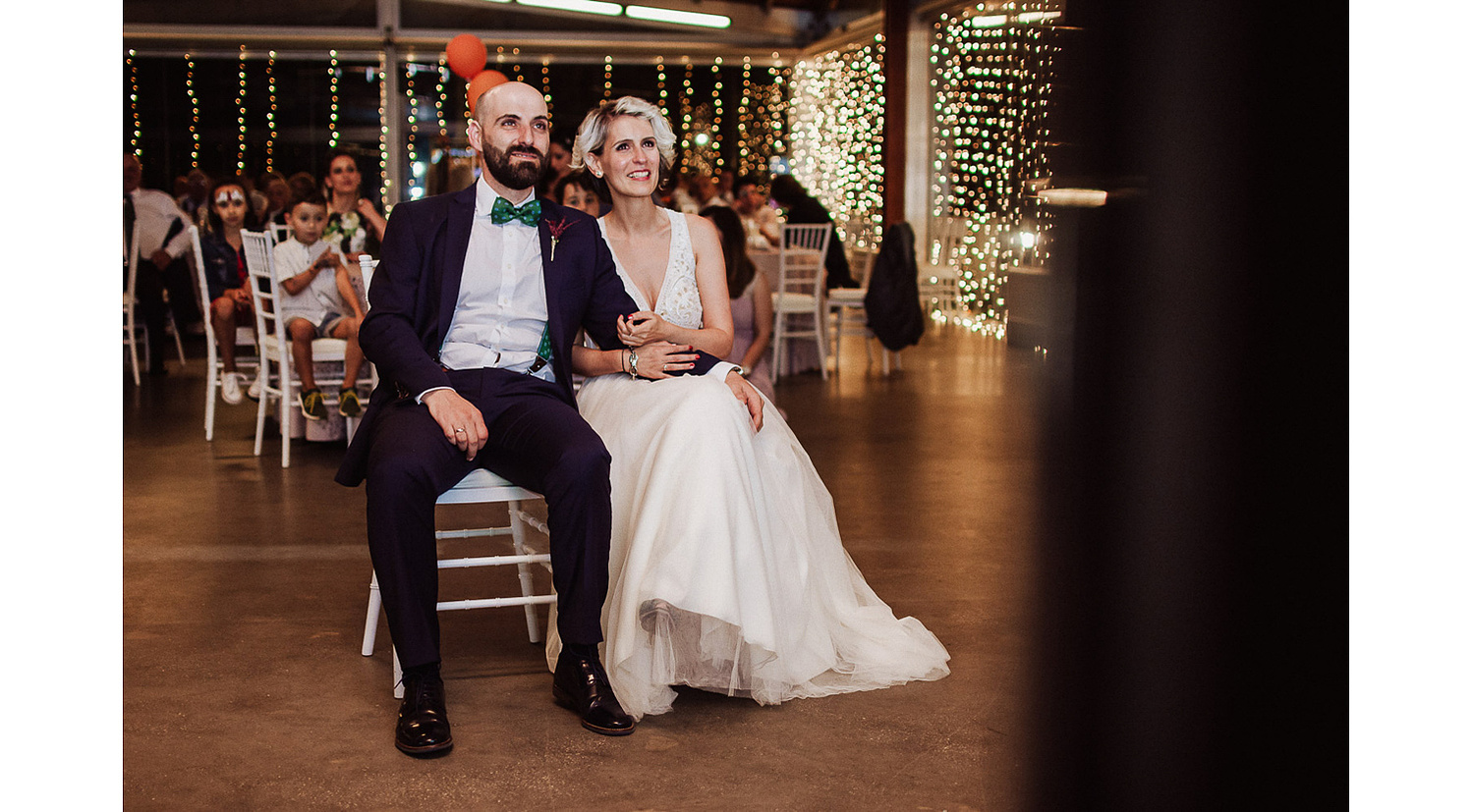 Novio y novia emocionados viendo video sorpresa en su boda