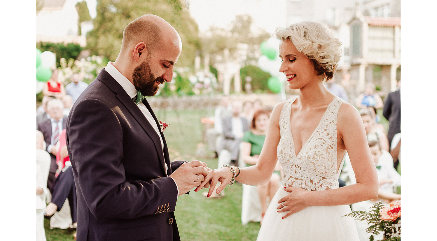 Novio coloca la alianza de boda a novia en boda en jardin
