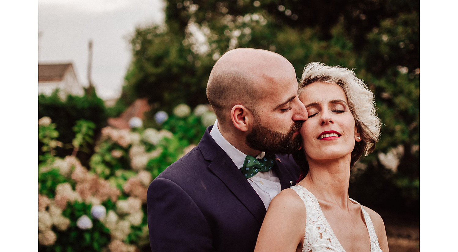 Fotografia de pareja novio besa a la novia en la mejilla con mucho amor