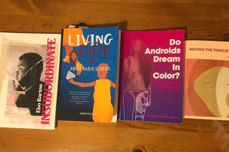 Four books by Filipinx/a/o authors placed side by side on a brown table