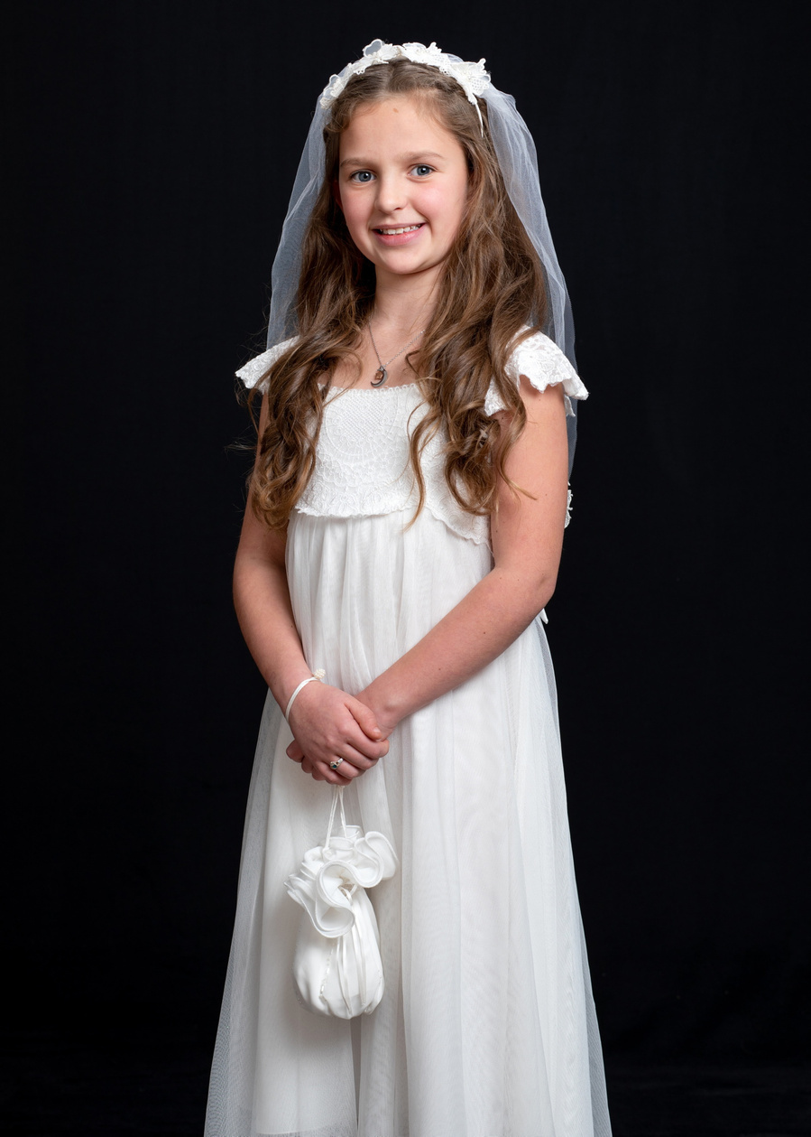 First Holy Communion Portrait of young girl taken in Professional Family Photography Studio with black background