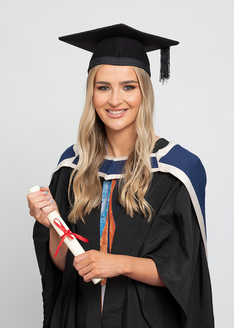 young female graduate student in professional photo studio graduation photographer dublin grey background