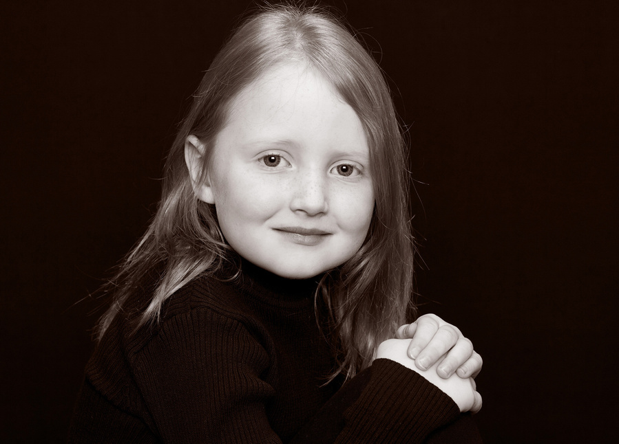 Classic black and white portrait of a young girl taken in a professional family photography studio 