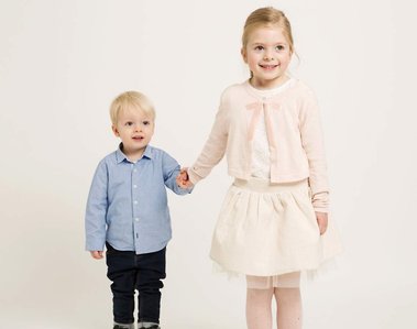 young brother and sister holding hands studio portrait 