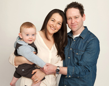 Mom and Dad holding baby and holding hands professional photography studio portrait