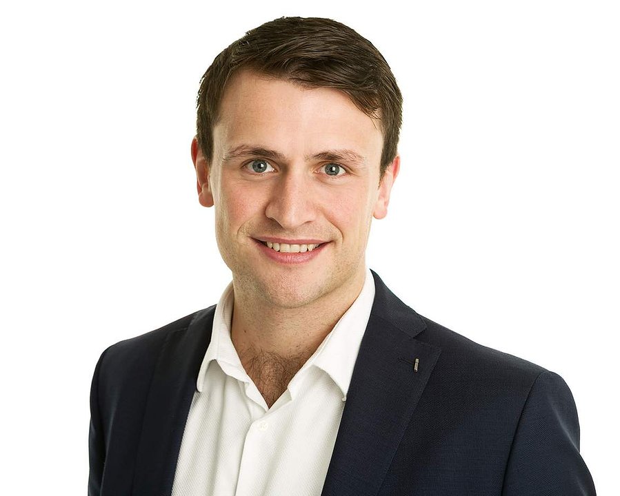 LinkedIn business headshot of young male  in professional photography studio white  background