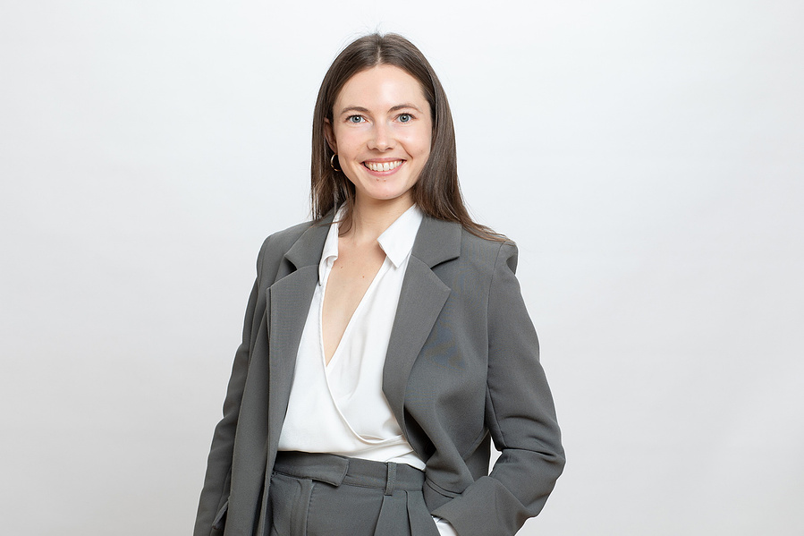 Professional 3/4 length portrait of a young female taken in a professional photography studio with a grey background, portrait for LinkedIn