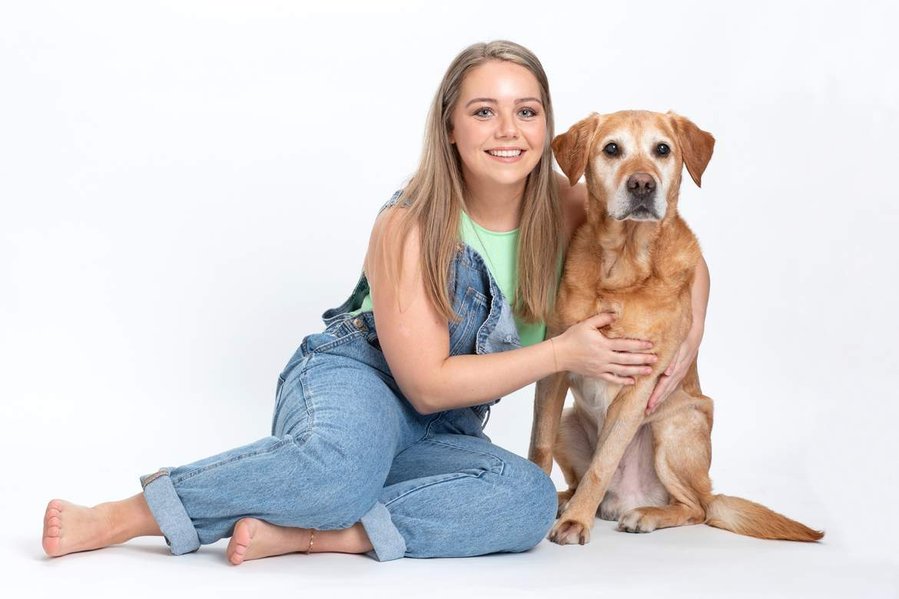 Pet portrait photography studio. Owner and golden labrador dog portrait in a professional family photo studio white background