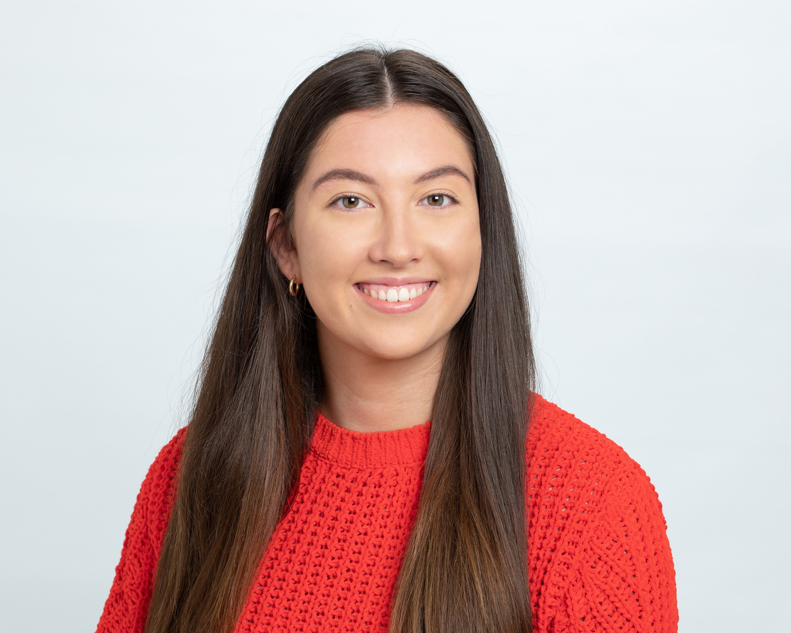 LinkedIn headshot of young female  in professional photography studio grey background