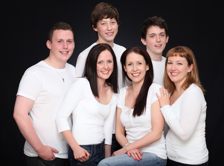 Group of Six adult siblings wearing white shirts photographed in a professional photography studio in dublin black background