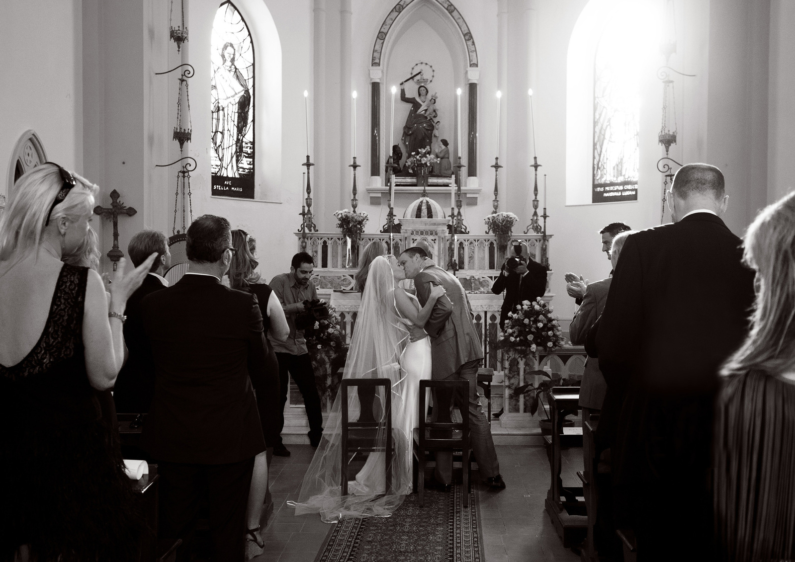 Wedding day photo of Bride and groom kissing at altar black and white reportage documentary style wedding photography