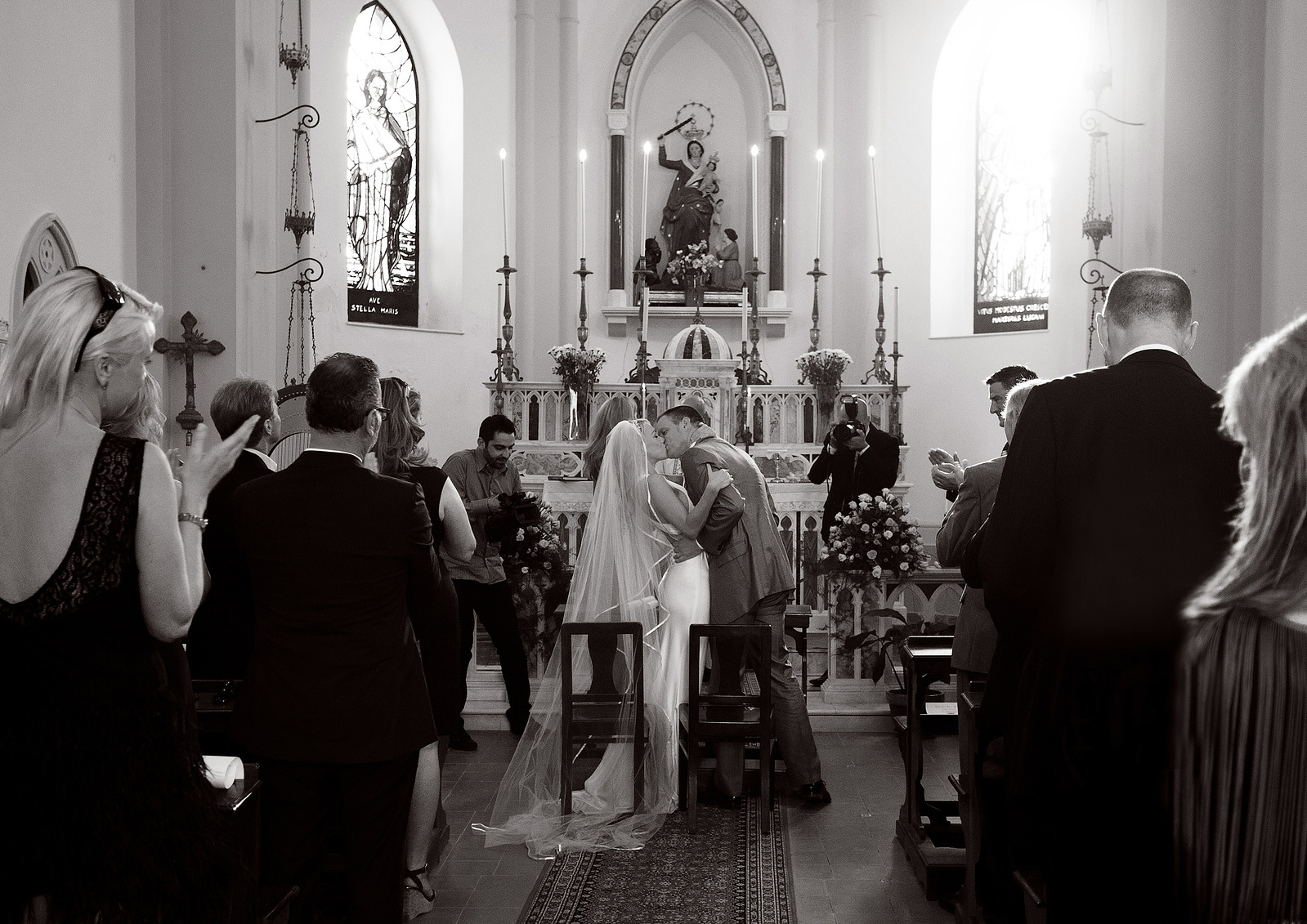 Wedding day photo of Bride and groom kissing at altar black and white reportage documentary style wedding photography