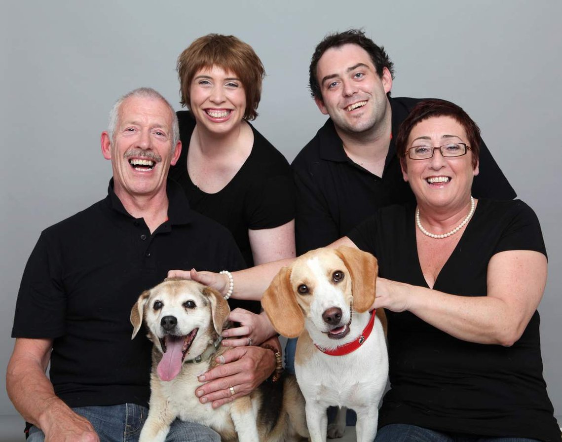 family wearing black in photography studio with two dogs family portrait Pet Portrait Photographer Dublin 