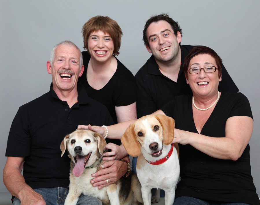 Classic pet owner portrait photography a couple with their two adult children and two family dogs in a professional pet photo studio in Dublin