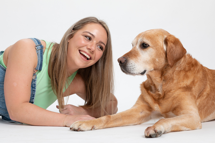 Pet portrait photography studio. Owner and golden labrador dog portrait in a professional family photo studio white background