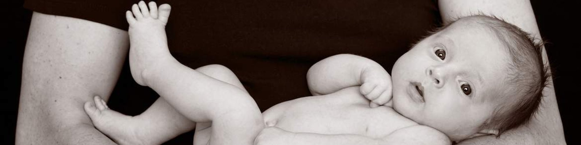 Studio photography of newborn in fathers arms Christening Gift Voucher idea