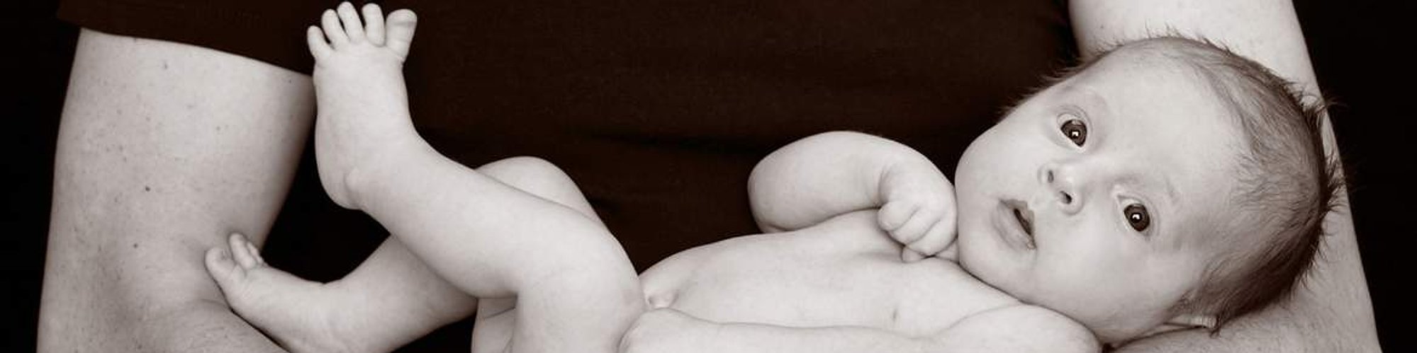 Studio photography of newborn in fathers arms Christening Gift Voucher idea