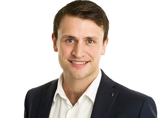 Business profile portrait headshot for LinkedIn of young male professional wearing white shirt and black blazer in photography studio with white background