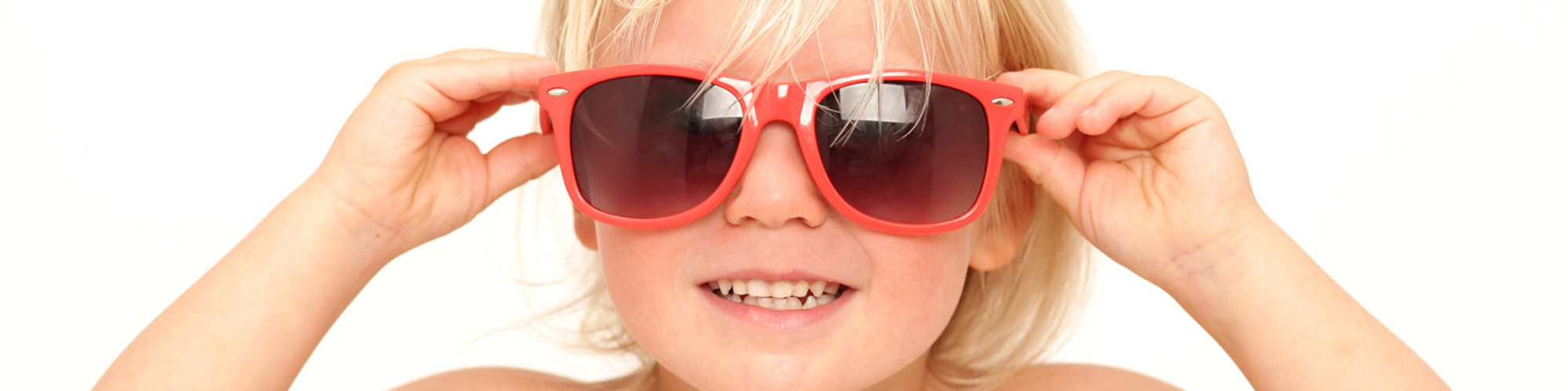 Young blonde boy wearing oversized red sunglasses taken in professional family photography photo studio in Dublin www.1portrait.ie
