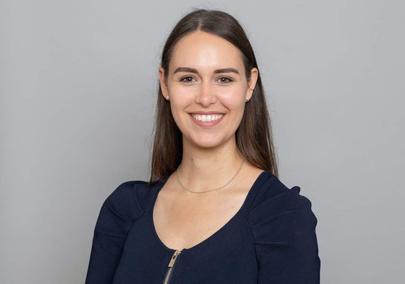 Professional business H&S headshot of young female wearing black top in Dublin corporate photography studio with plain grey background 