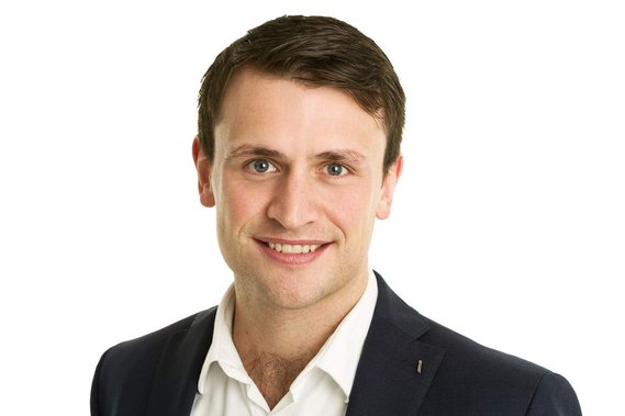 Professional business H&S headshot of young male wearing black jacket in Dublin photography studio with plain white background 