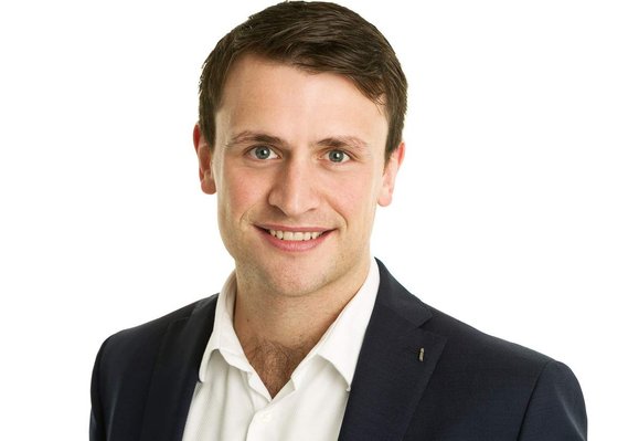 Business profile portrait headshot for LinkedIn of young male professional wearing white shirt and black blazer in photography studio with white background