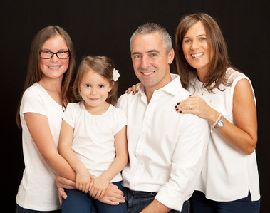 Family portrait of parents and two young daughters in professional photo studio Dublin unique christmas gift